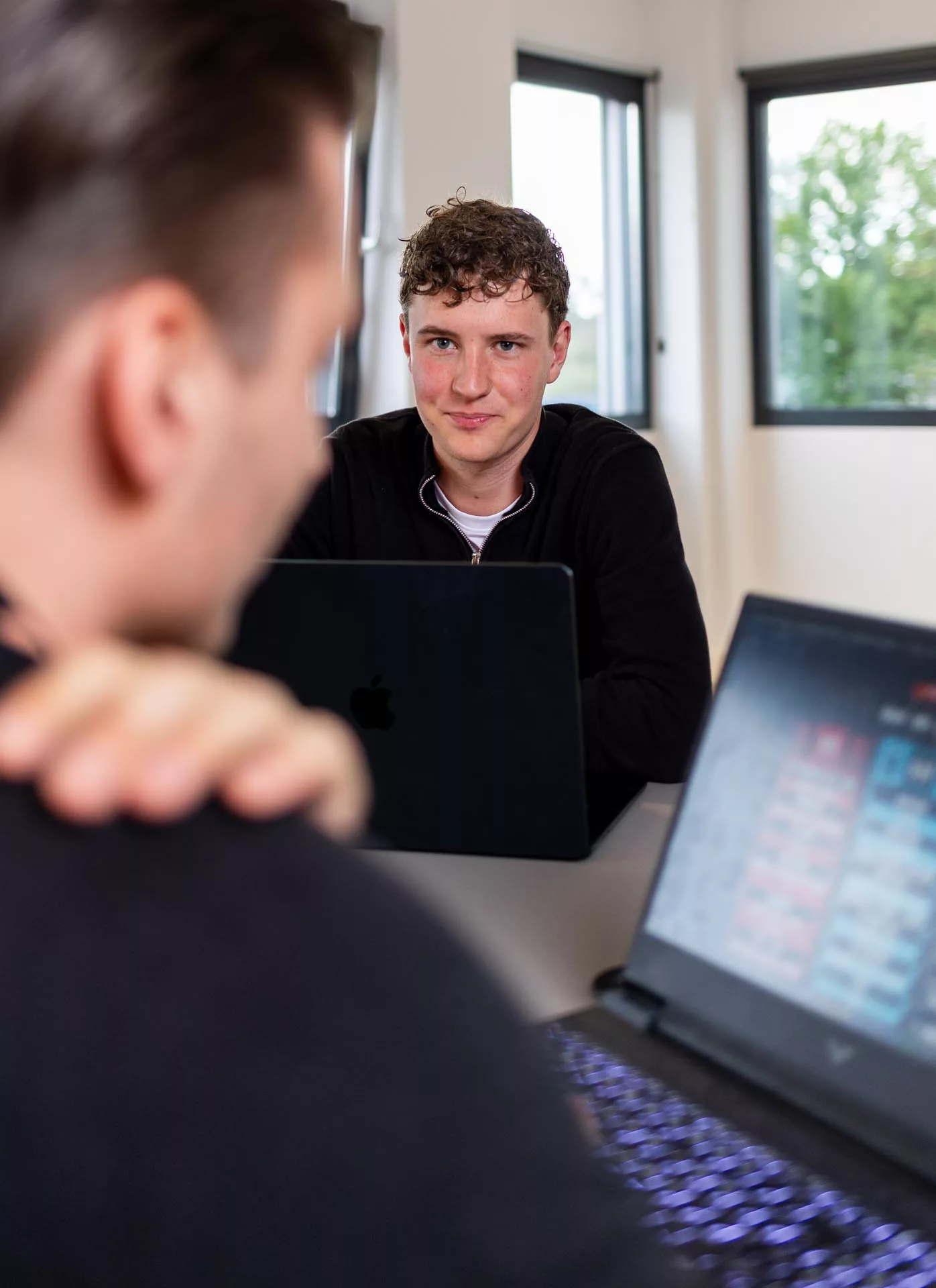 Bob Beissel kijkt naar Dyon Grob tijdens technische afstemming op kantoor bij Msquad